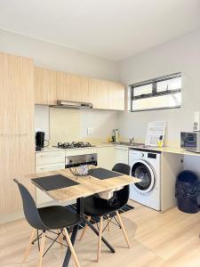 a kitchen with a table and a washing machine at Broadacres apartment-work or play -swimming pool in Sandton