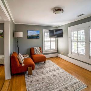a living room with two chairs and a flat screen tv at Hellbender Bed & Beverage in Blowing Rock