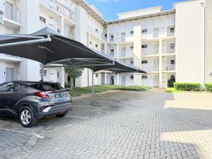 a car parked in a parking lot with a large umbrella at Broadacres apartment-work or play -swimming pool in Sandton