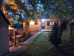 a house with a bench in the yard at night at Seoski raj in Podgorica