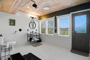 a bathroom with a black door and a white tile floor at St. Croix Valley Inn in Shafer +92 photos