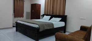 a bedroom with a bed and a couch and a chair at Hotel N Pride in Guntūr