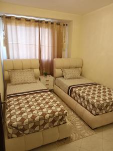 ein Schlafzimmer mit zwei Betten und einer Couch in der Unterkunft Confort Flat in Salé + 3 Fotos