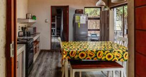 a kitchen with a table with a sunflower blanket on it at Mabalingwe Nature Reserve - Elephant Lodge - Tjaila in Warmbaths