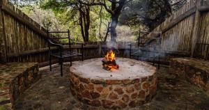 a fire pit in a yard with a chair and stairs at Mabalingwe Nature Reserve - Elephant Lodge - Tjaila in Warmbaths