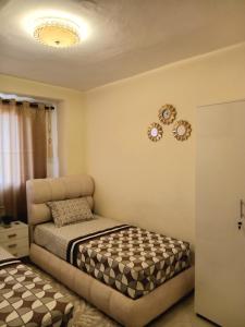 ein Schlafzimmer mit einem Bett und einer Uhr an der Wand in der Unterkunft Confort Flat in Salé