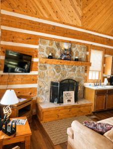a living room with a stone fireplace in a cabin at Beary Cozy- Tiny Cabin Getaway! in Sevierville