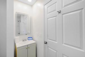 a white bathroom with a sink and a door at Peaceful Horizons at The Heron's Rest in Biloxi +24 photos