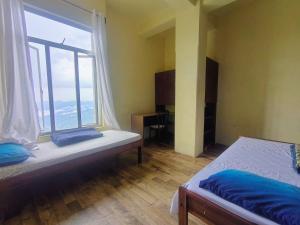 a bedroom with a bed and a large window at Mizotel in Āīzawl