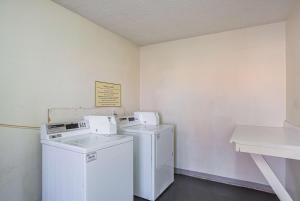 a laundry room with two washer and dryer at San Mateo Inn in Albuquerque