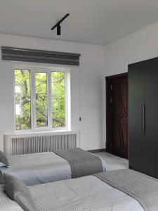 a bedroom with two beds and a window at GUEST HOUSE "Rohat Lux" in Samarkand +60 photos