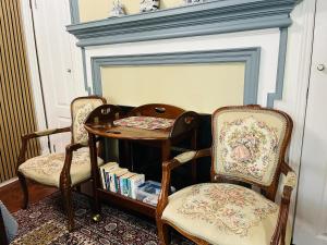two chairs and a table in front of a fireplace at Barkerhouse 2# unit-heart of oldtown in Niagara-on-the-Lake