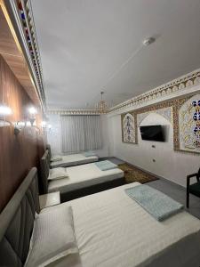 a room with a bunch of beds in it at MUXSIN s in Bukhara
