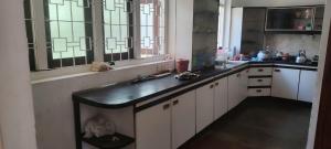 a kitchen with white cabinets and a black counter top at Deepthi Villa in Nikawatawana