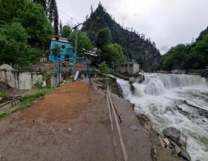 a river with a waterfall in front of a mountain at The Cozy Cottage in Kundālshai