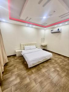 a bedroom with a white bed in a room at Chalets Zara شاليهات زارا in Taif