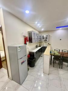 a kitchen with a refrigerator and a table at Chalets Zara شاليهات زارا in Taif