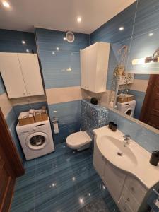 a bathroom with a toilet a sink and a washing machine at Silent Apartment Płock in Płock +8 photos