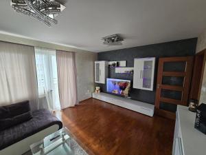 a living room with a couch and a flat screen tv at Silent Apartment Płock in Płock