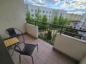 a balcony with two chairs and a railing with a view at Silent Apartment Płock in Płock