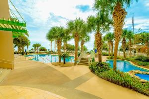 a swimming pool with palm trees in a resort at Legacy Tower I in Gulfport