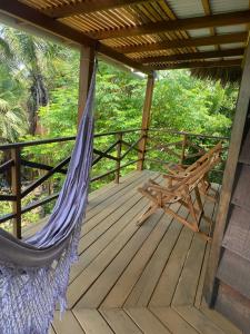 a hammock and a bench on a deck at Estrela dos Lençóis in Atins