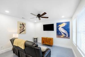a living room with a black leather couch and a tv at Peaceful Horizons at The Heron's Rest in Biloxi