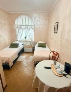 a bedroom with two beds and a table and a window at IDEAL in Płock