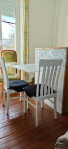 a dining room with a white table and two chairs at La grenouille des thermes in Vittel