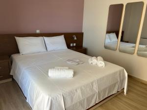 a bedroom with a bed with two towels and mirrors at Sea Sparkle 1a in Preveza
