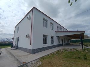 a large white building with a porch on a field at Отель Гетьман in Broska