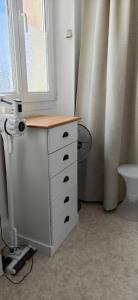 a bathroom with a white dresser and a window at La grenouille des thermes in Vittel