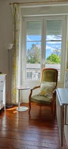 a living room with a chair and a window at La grenouille des thermes in Vittel