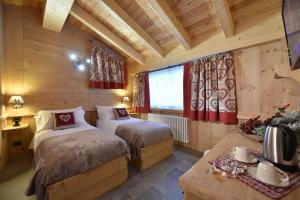 a bedroom with two beds in a log cabin at Il Cuore Del Cervino in Breuil-Cervinia