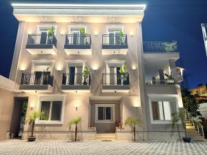 a white building with potted plants in front of it at Maison Apartments in Vlorë