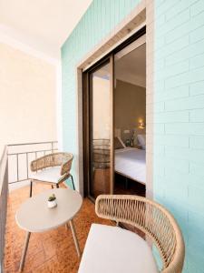 a room with a table and two chairs and a bed at Pensión Rocamar in Almuñécar