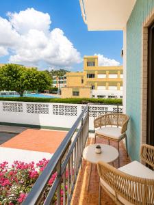 a balcony with two tables and chairs and a building at Pensión Rocamar in Almuñécar