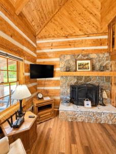 a living room with a stone fireplace in a log cabin at Lover's Leap in Sevierville