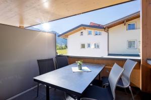 a table and chairs in a room with a large window at Apart Oberau - new from 2026 in Hippach
