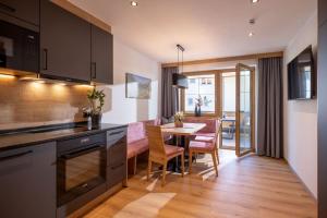 a kitchen and dining room with a table and chairs at Apart Oberau - new from 2026 in Hippach +29 photos