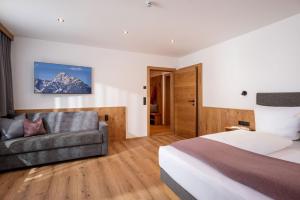 a hotel room with a bed and a couch at Apart Oberau - new from 2026 in Hippach