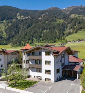an apartment building with mountains in the background at Apart Oberau - new from 2026 in Hippach