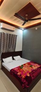 a bedroom with a bed with a flower blanket on it at OM DAYAMA Please in Khātu