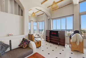 a living room with a couch and a tv at Surf Appart Morocco in Tamraght Ouzdar