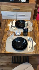a table with a black plate and glasses on it at Golden Leaf Apartment with Parking in Burghausen