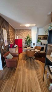 a living room with wooden floors and a red refrigerator at Golden Leaf Apartment with Parking in Burghausen
