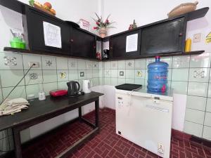 a small kitchen with a table and a refrigerator at Wayra Hostel Huanchaco in Huanchaco +48 photos