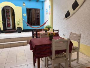 a table and chairs in a room with a table and a table at Wayra Hostel Huanchaco in Huanchaco