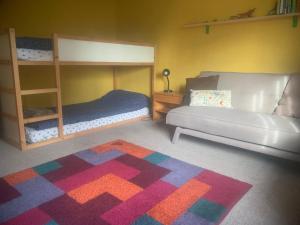 a bedroom with two bunk beds and a couch at Spacious Suffolk Cottage in Village Setting in Westleton