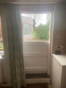 a bathroom with a window with a shower and a curtain at Spacious Suffolk Cottage in Village Setting in Westleton